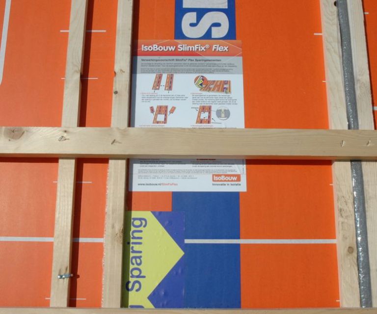Close-up van een dakplaat van BEWI IsoBouw waar een verwerkingsvoorschrift van SlimFix Flex op ligt.