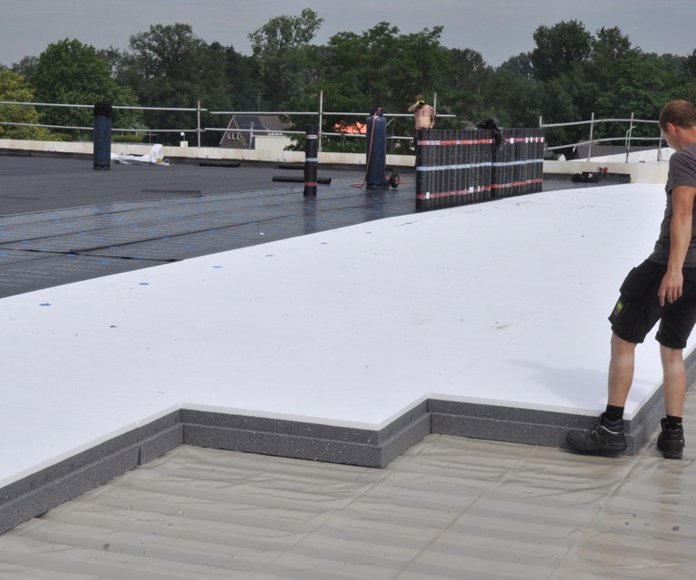 Projectfoto van een verwerker die een PowerTop Protect platdak isolatieplaat legt. 