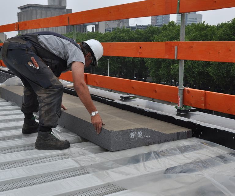 Projectfoto van een verwerker die een RenoTop HR afschotplaat tegen de dakrand legt. 