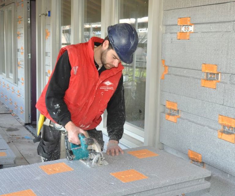 Projectfoto van een verwerker die een SlimFort gevelisolatieplaat inkort voor een SlimFort gevel.