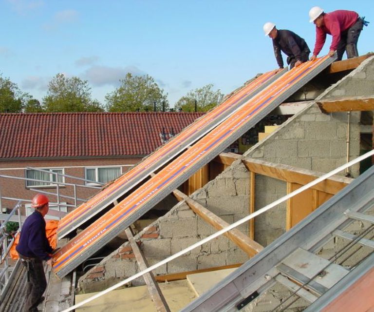 Projectfoto van dakdekkers die SlimFix dakelementen op de gording aan het plaatsen zijn.