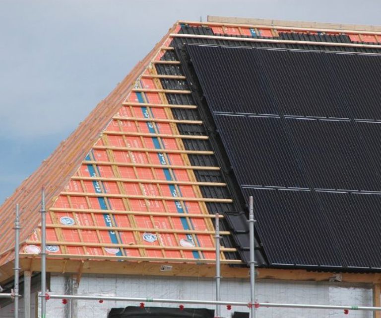 Projectfoto van oranje dakelementen met daarop een aantal solar modules en zonnepanelen.